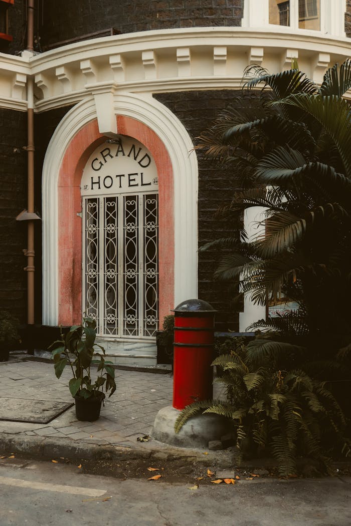portfolio-03 A vintage entrance of the Grand Hotel showcasing classic architectural design and lush greenery.